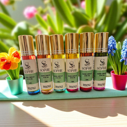 Collection of Sophie Dark Circle Eye Oils with Bakuchiol and Prickly Pear in colorful bottles displayed with flowers.