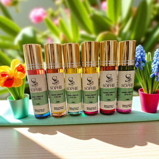 Collection of Sophie Dark Circle Eye Oils with Bakuchiol and Prickly Pear in colorful bottles displayed with flowers.
